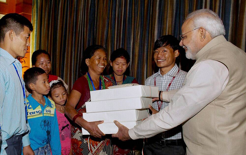 Prime Minister Narendra Modi giving presents to the family of Jeet Bahadur (2R) in Kathmandu, Nepal.