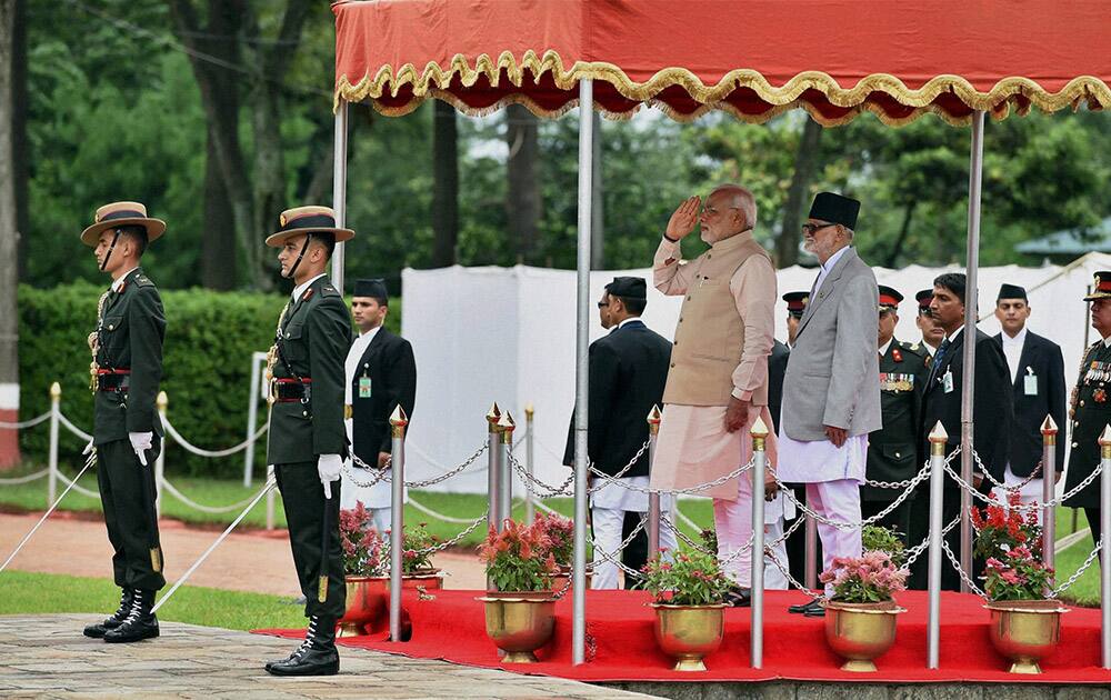 Prime Minister Narendra Modi during the official welcome ceremony on his arrival at VVIP lounge compound seen with his Nepalese counterpart Sushil Koirala (L) at Tribhuvan International Airport in Kathmandu, Nepal.