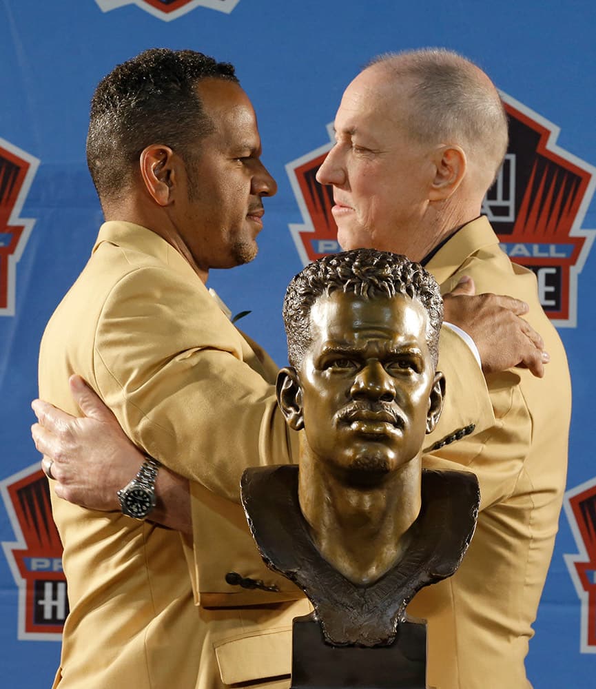 Hall of Fame inductee Andre Reed, left, and former Buffalo Bills quarterback Jim Kelly hug during the Pro Football Hall of Fame enshrinement ceremony in Canton, Ohio.
