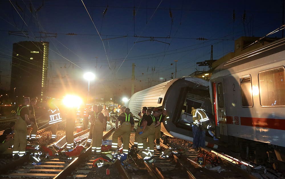Fire fighters stand near the Mannheim train station after a trainaccident in Mannheim, Germany. Two cars of a train tipped over following a collision late Friday authorities said, injuring a number of passengers.