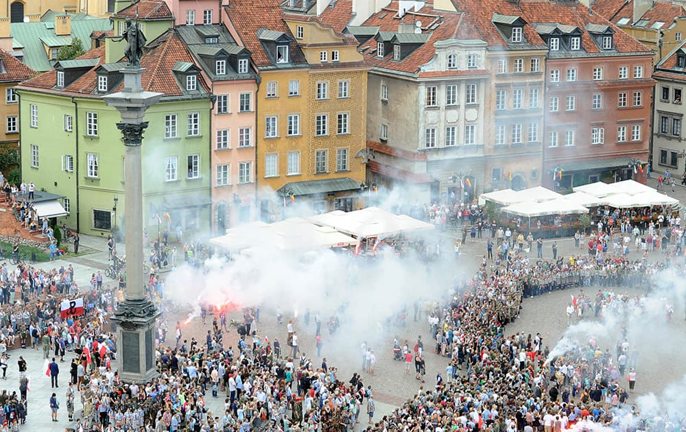 People attend a minute of silence to commemorate the 70th anniversary of the 1944 Warsaw Uprising in Warsaw.