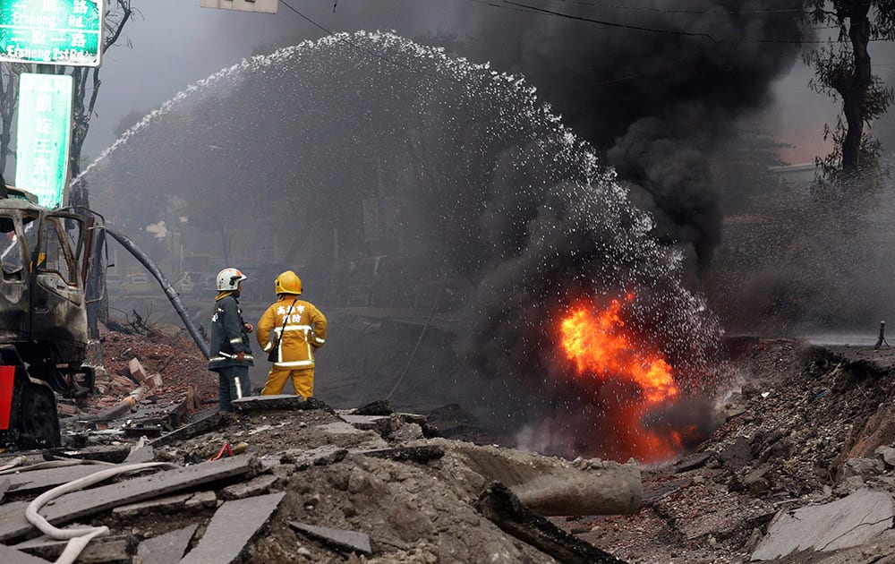 Firemen put out fire on the part of a destroyed street as fire continue to burn following multiple explosions from an underground gas leak in Kaohsiung, Taiwan.