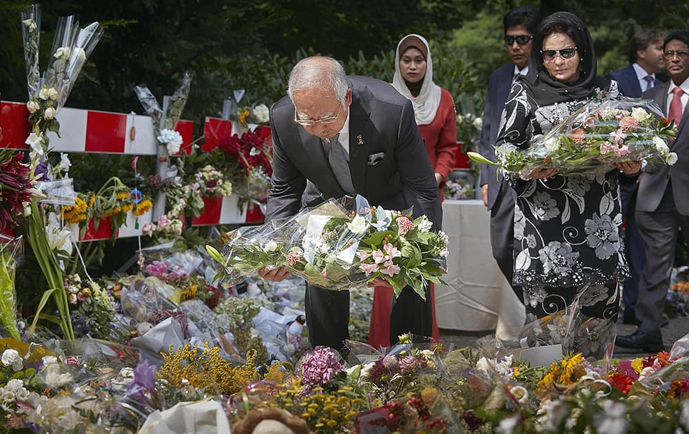 Malaysian Prime Minister Najib Razak and his wife Datin Sri Rosmah Mansor lay flowers outside a military barracks where forensic experts are working to identify bodies and human remains recovered from the wreckage of Flight 17, in the central city of Hilversum, Netherlands.