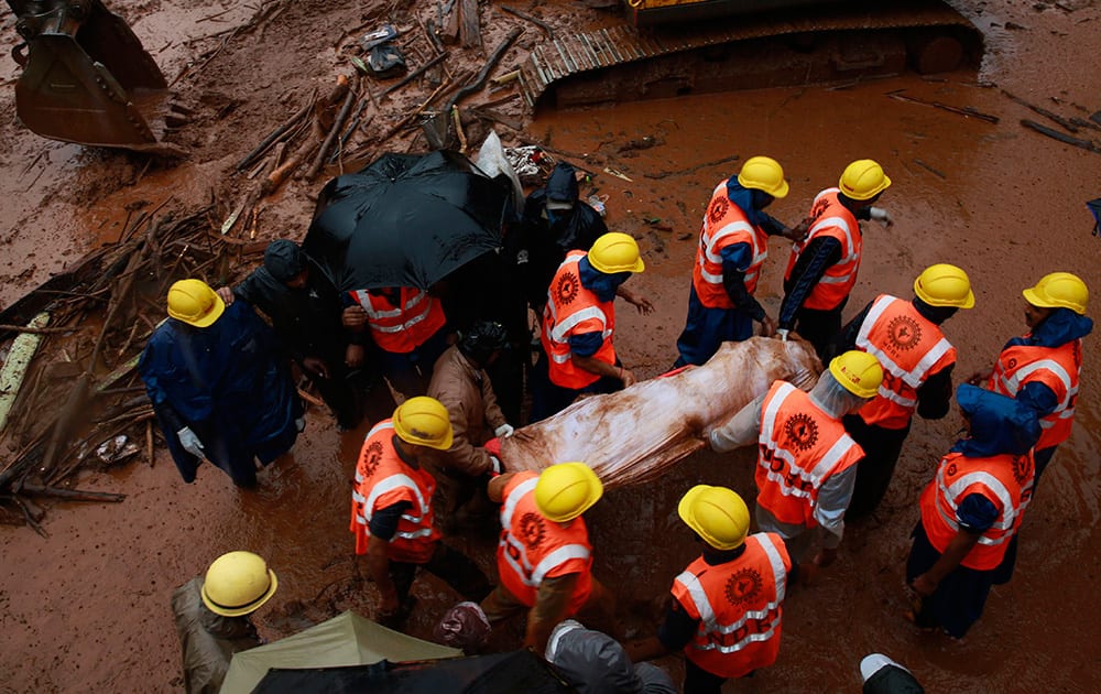 Rescue workers carry the body of a victim after a massive landslide in Malin village in Pune district of western Maharashtra state.