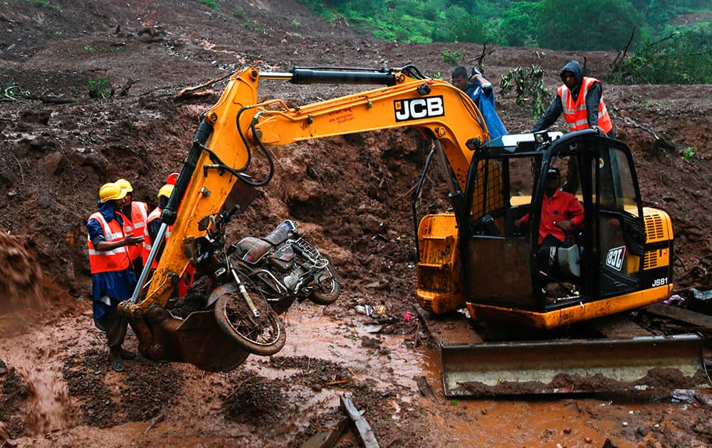 Rescue workers retrieve a motorcycle from the site of a massive landslide in Malin village in Pune district of western Maharashtra state.