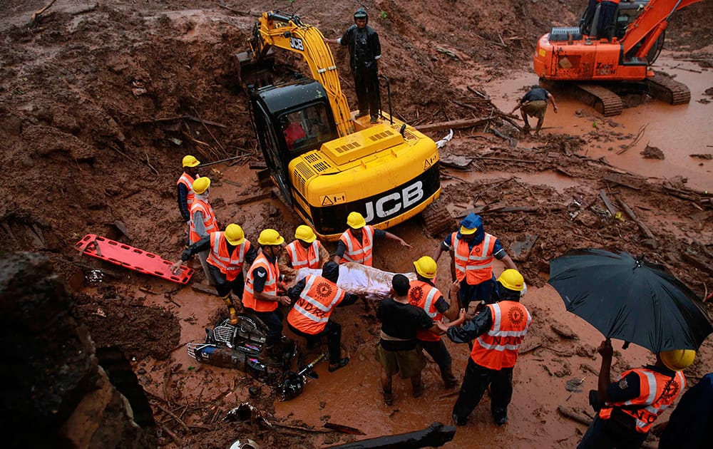 Rescue workers carry the body of a victim after a massive landslide in Malin village in Pune district of western Maharashtra state.