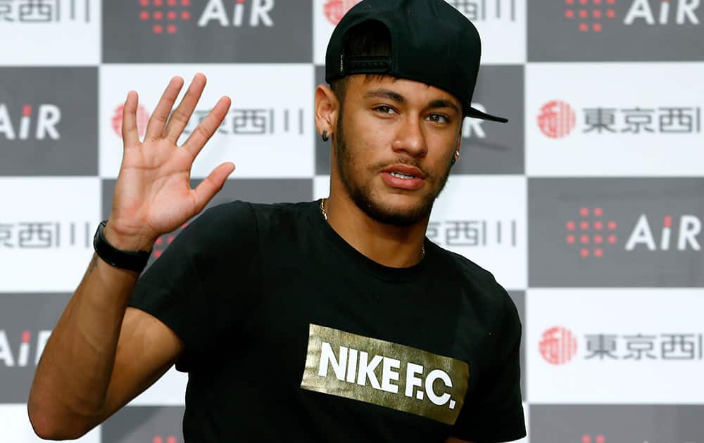 Brazil`s soccer player Neymar waves for the media during a press conference at a hotel in Tokyo.