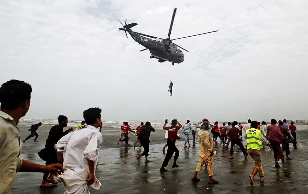A Pakistan Navy helicopter evacuates a recovered body of a victim who drowned over Clifton beach in Karachi, Pakistan.