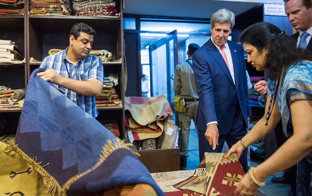 US Secretary of State, John Kerry, looks at carpets during a visit to the Central Cottage Industries Emporium in New Delhi.