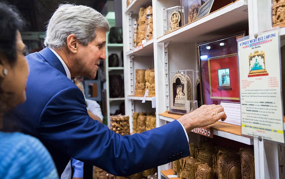 US Secretary of State, John Kerry, looks at a rice carving during a visit to the Central Cottage Industries Emporium in New Delhi.