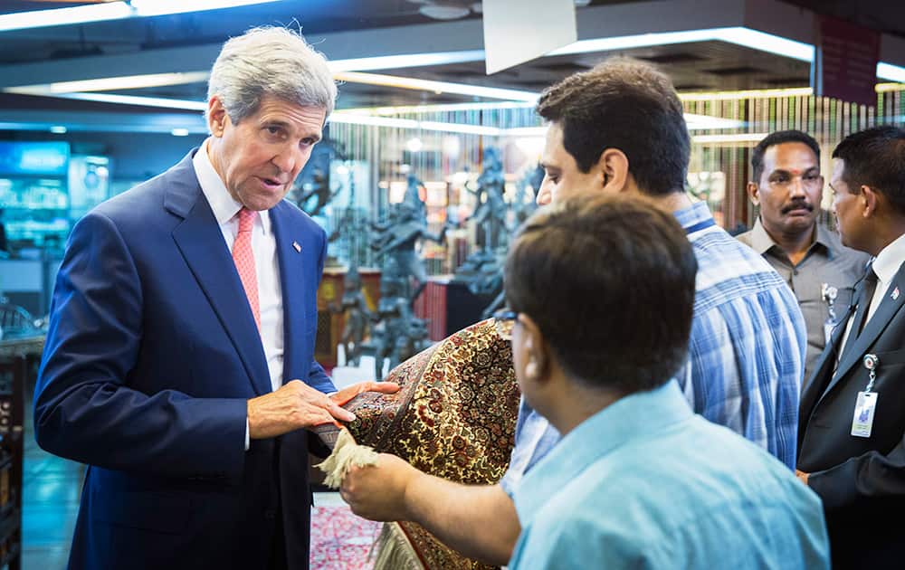 US Secretary of State, John Kerry is shown a carpet made in Kashmir during a visit to the Central Cottage Industries Emporium in New Delhi.