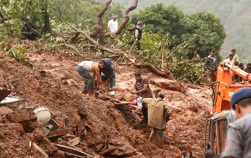 Rescue workers carry the body of a victim at the site of a landslide in Malin village, in the western Indian state of Maharashtra.