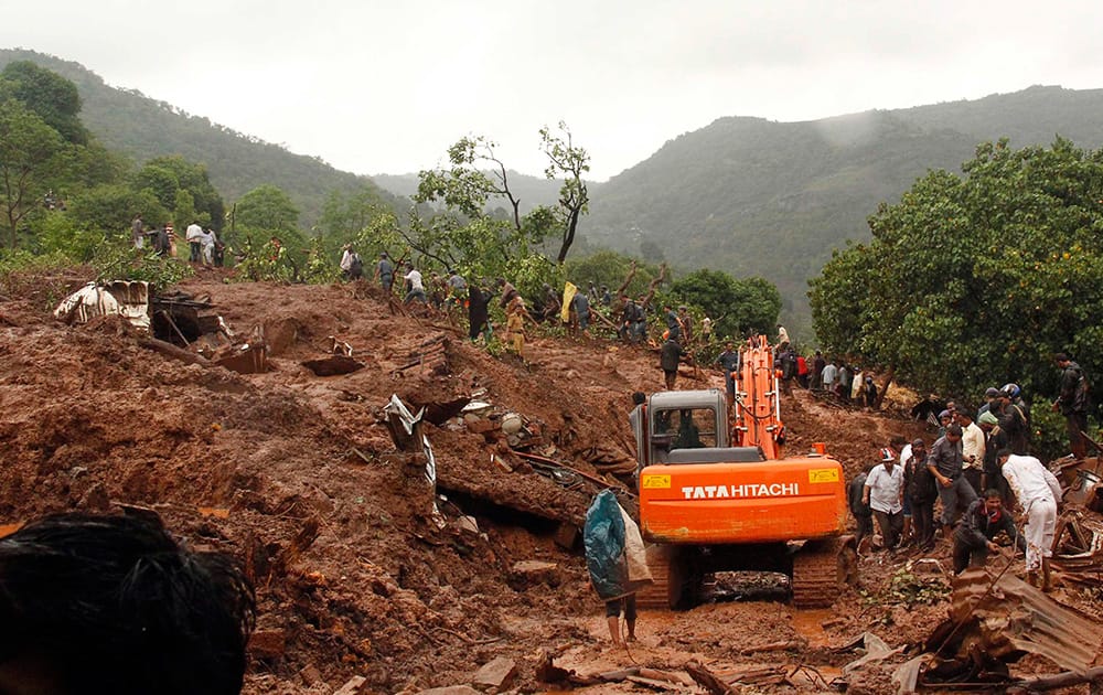 Rescue workers clear the debris at the site of a landslide in Malin village, in the western Indian state of Maharashtra.