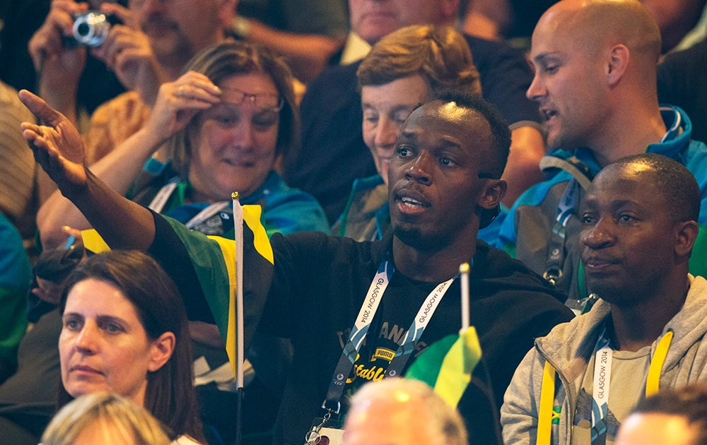 Double Olympic champion Usain Bolt of Jamaica, centre, watches the women`s pool A netball match between Jamaica and New Zealand at the Commonwealth Games Glasgow 2014, in Glasgow, Scotland.