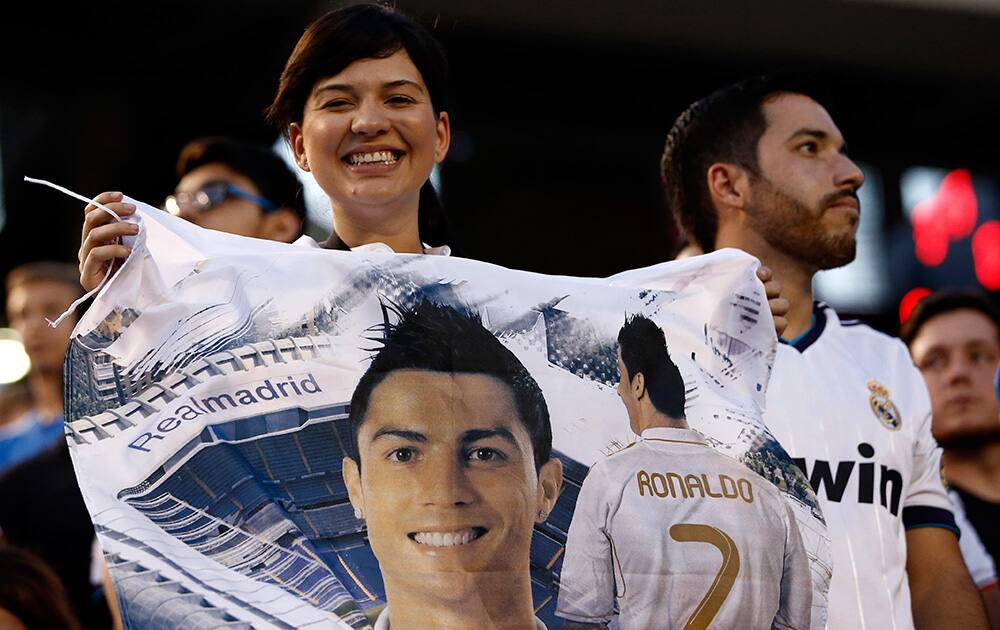 A fan poses with a flag bearing the image of Cristiano Ronaldo at the 2014 Guinness International Champions Cup: AS Roma v. Real Madrid match in Dallas, TX.