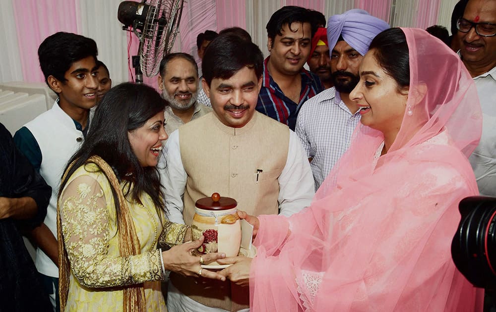 Union Minister Harsimrat Kaur greets BJP MP Syed Shahnawaz Hussain and his wife Renu on the occasion of Eid-Ul-Fitr in New Delhi.