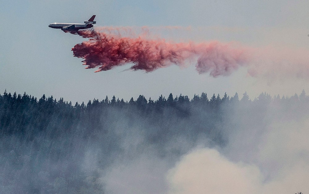 A plane drops fire retardant as firefighters battle a blaze in El Portal, Calif., near Yosemite National Park.