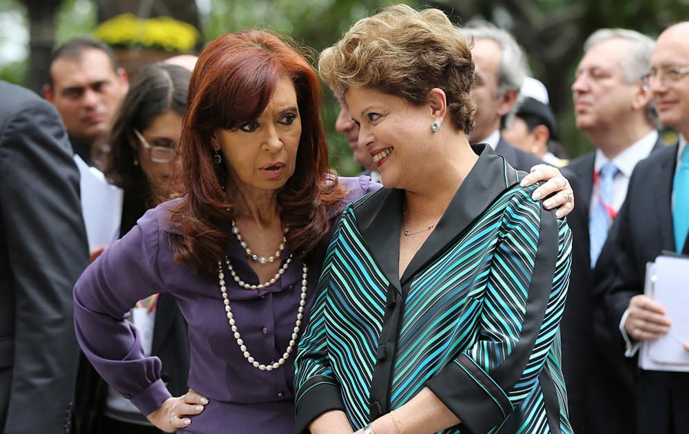 Argentina`s President Cristina Fernandez, left, speaks with Brazil`s Dilma Rousseff, as they arrive at Bolivar Square, for the official Mercosur Summit photo of leaders, in Caracas, Venezuela.