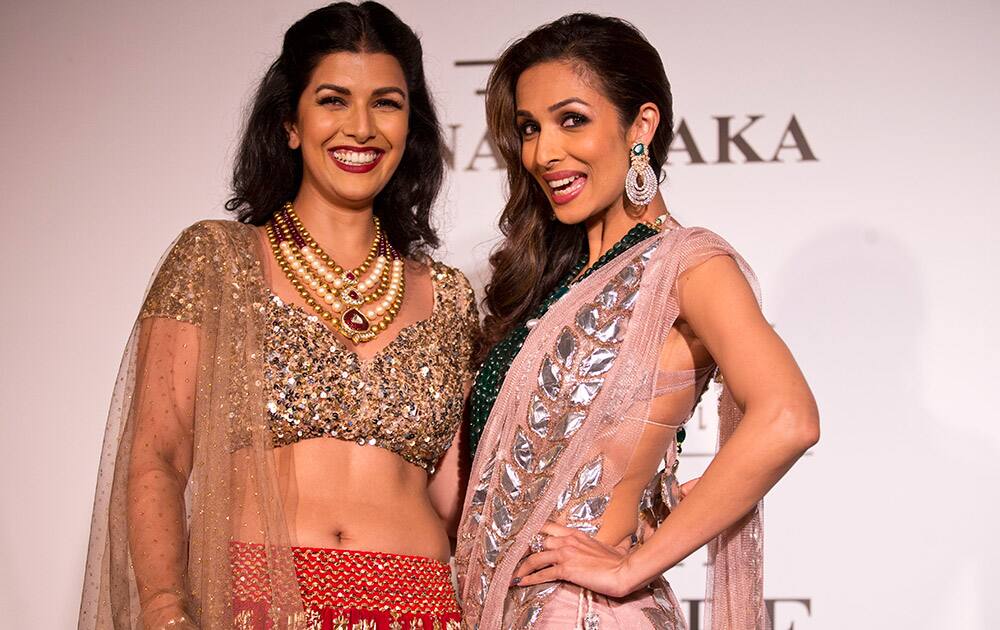 Actors Malaika Arora, right, and Nimrat Kaur pose with dresses created by Indian designer Rina Dhaka at the India Couture Week, held by Fashion Design Council of India.