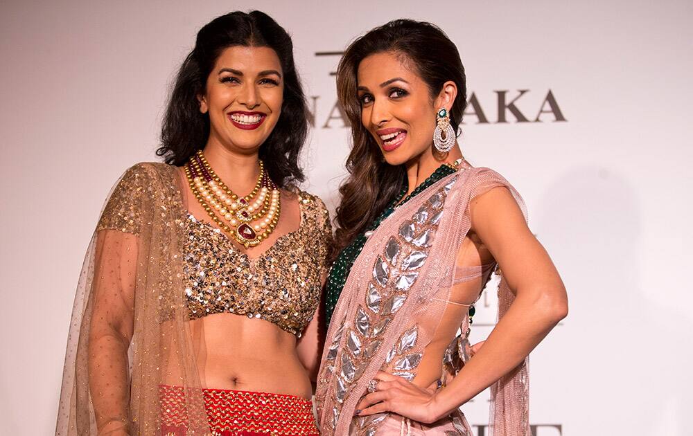 Actors Malaika Arora, right, and Nimrat Kaur pose with dresses created by Indian designer Rina Dhaka at the India Couture Week, held by Fashion Design Council of India, in New Delhi.