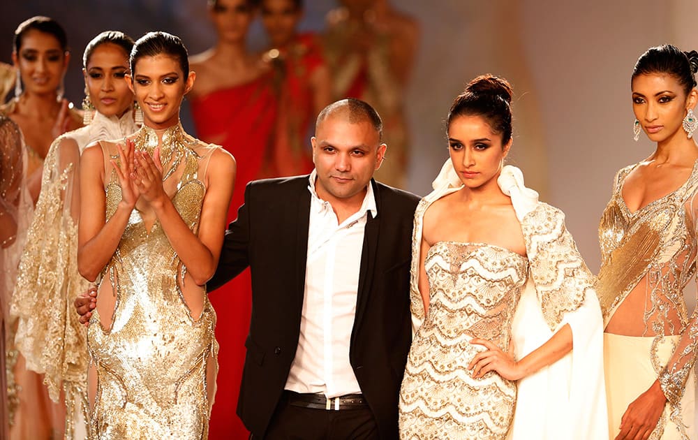 Designer Gaurav Gupta poses with models after a fashion show displaying dresses designed by him at the India Couture Week, held by Fashion Design Council of India, in New Delhi.