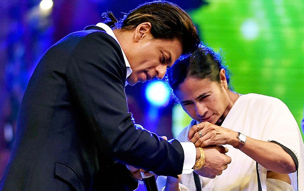 West Bengal Chief Minister Mamata Banerjee ties Rakhi on the wrist of Bollywood actor Shahrukh Khan to celebrate 'Rakshabandhan'during Kolkata Police Programme in Kolkata.