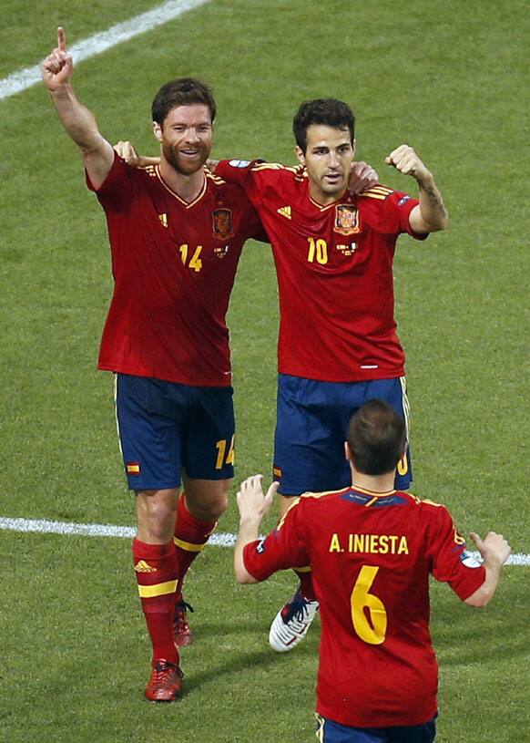 Spain's Xabi Alonso celebrates scoring the opening goal with his teammates Cesc Fabregas, right, and Andres Iniesta during the Euro 2012 soccer championship quarterfinal match between Spain and France in Donetsk, Ukraine, Saturday, June 23, 2012. 