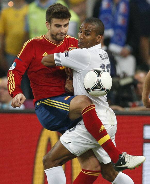 Spain's Gerard Pique, left, and France's Florent Malouda challenge for the ball during the Euro 2012 soccer championship quarterfinal match between Spain and France in Donetsk, Ukraine, Saturday, June 23, 2012. 