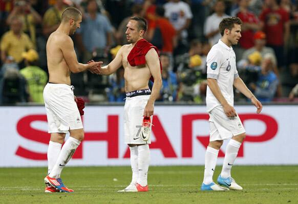 France's Karim Benzema, left, shakes hand with Franck Ribery as their teammate Yohan Cabaye leaves the pitch during the Euro 2012 soccer championship quarterfinal match between Spain and France in Donetsk, Ukraine.