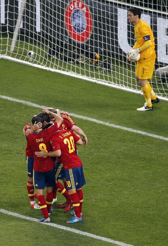 France goalkeeper Hugo Lloris holds the ball as Spain players celebrate scoring during the Euro 2012 soccer championship quarterfinal match between Spain and France in Donetsk, Ukraine.