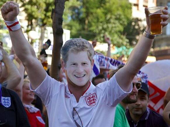 An England soccer fan wears a mask of Britain's Prince Harry and cheers for his team ahead of the Euro 2012 soccer championship quarterfinal match between England and France at the Fan Zone in Kiev Ukraine, Sunday, June 24, 2012.