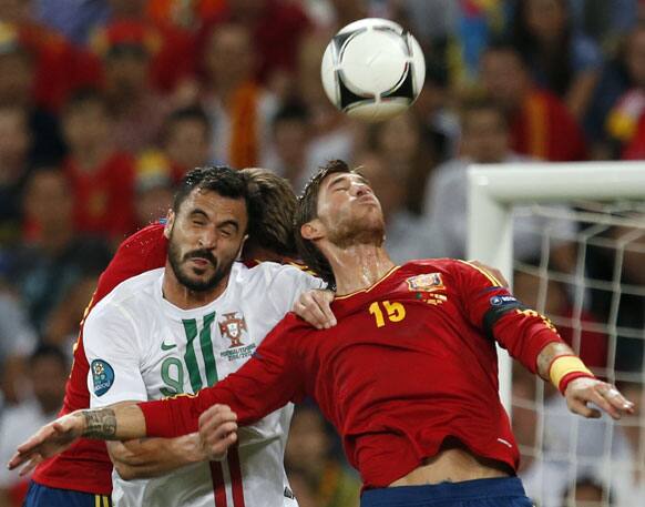 Portugal's Hugo Almeida, left, and Spain's Gerard Pique and Sergio Ramos, right, go for a header during the Euro 2012 soccer championship semifinal match between Spain and Portugal in Donetsk, Ukraine.