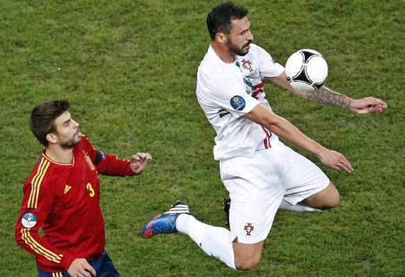 Spain's Gerard Pique, left, looks on as Portugal's Hugo Almeida controls the ball during the Euro 2012 soccer championship semifinal match between Spain and Portugal in Donetsk, Ukraine, Wednesday, June 27, 2012.