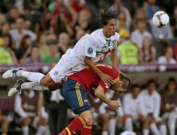 Portugal's Bruno Alves, top, falls over Spain's Alvaro Negredo during the Euro 2012 soccer championship semifinal match between Spain and Portugal in Donetsk, Ukraine, Wednesday, June 27, 2012.