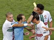 Referee Cuneyt Cakir of Turkey, second left, books Portugal's Fabio Coentrao, as his teammates Pepe and Bruno Alves react beside them during the Euro 2012 soccer championship semifinal match between Spain and Portugal in Donetsk, Ukraine, Wednesday, June 27, 2012.