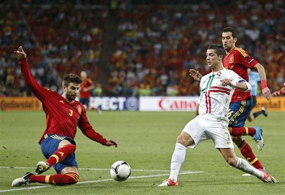 Spain's Gerard Pique clears the ball in front of Portugal's Cristiano Ronaldo during the Euro 2012 soccer championship semifinal match between Spain and Portugal in Donetsk, Ukraine, Wednesday, June 27, 2012.