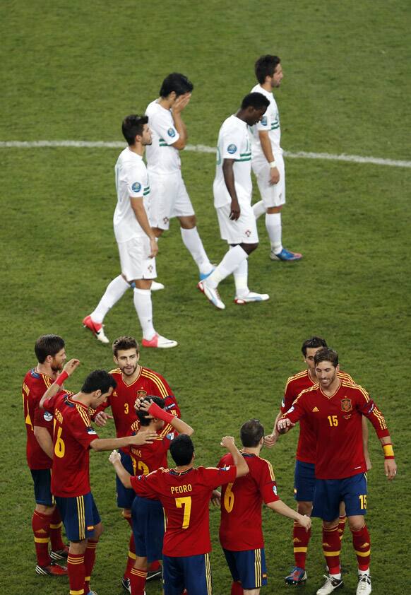 Portuguese players react as Spanish players celebrate after the penalty shootout of the Euro 2012 soccer championship semifinal match between Spain and Portugal in Donetsk, Ukraine.