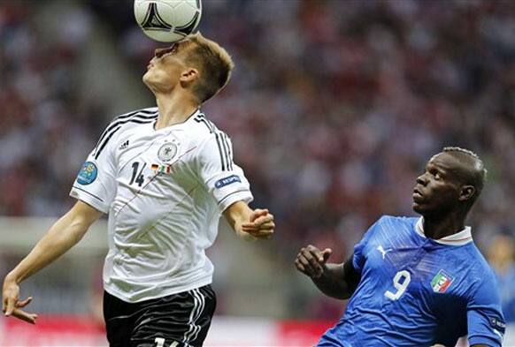 Germany's Holger Badstuber heads the ball in front of Italy's Mario Balotelli during the Euro 2012 soccer championship semifinal match between Germany and Italy in Warsaw, Poland, Thursday, June 28, 2012. 