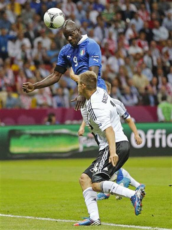 Italy's Mario Balotelli scores by Germany's Holger Badstuber during the Euro 2012 soccer championship semifinal match between Germany and Italy in Warsaw, Poland, Thursday, June 28, 2012. 