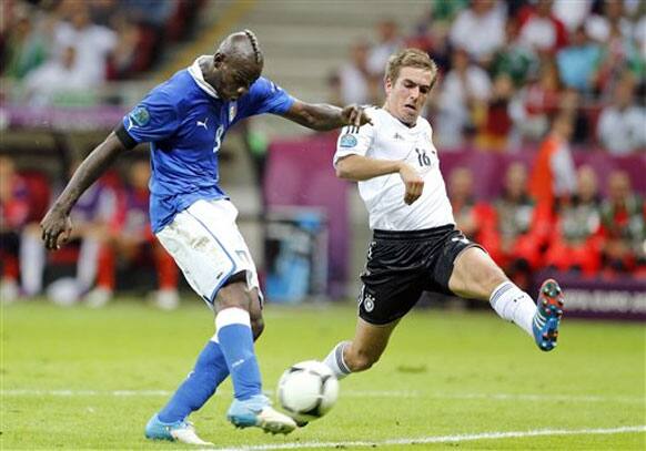 Italy's Mario Balotelli scores his team's second goal by Germany's Philipp Lahm during the Euro 2012 soccer championship semifinal match between Germany and Italy in Warsaw, Poland, Thursday, June 28, 2012. 