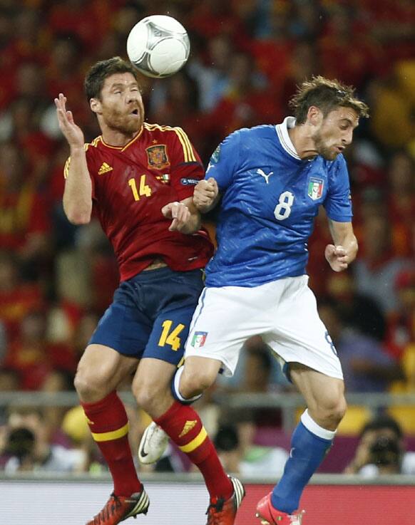 Spain's Xabi Alonso, left, and Italy's Claudio Marchisio jump for the ball during the Euro 2012 soccer championship final between Spain and Italy in Kiev.