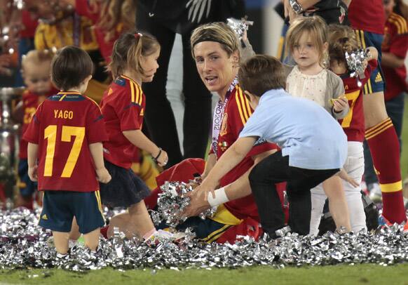 Children brought onto the pitch by celebrating Spanish surround Spain's Fernando Torres during the Euro 2012 soccer championship final between Spain and Italy in Kiev, Ukraine.