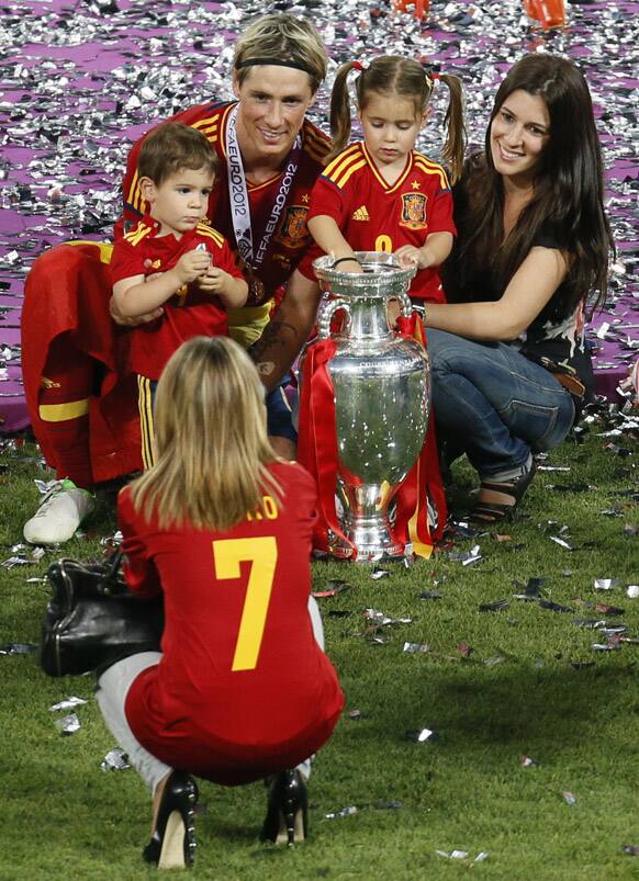 Spain's Fernando Torres, his wife Olalla, right, pose with the trophy for a photograph after Spain won the Euro 2012 soccer championship final between Spain and Italy in Kiev, Ukraine.