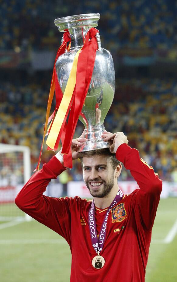 Spain's Gerard Pique celebrates with the trophy after winning the Euro 2012 soccer championship final between Spain and Italy in Kiev, Ukraine.