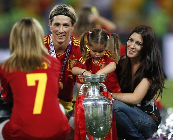 Spain's Fernando Torres, his wife Olalla, right, pose with the trophy for a photograph after Spain won the Euro 2012 soccer championship final between Spain and Italy in Kiev, Ukraine.