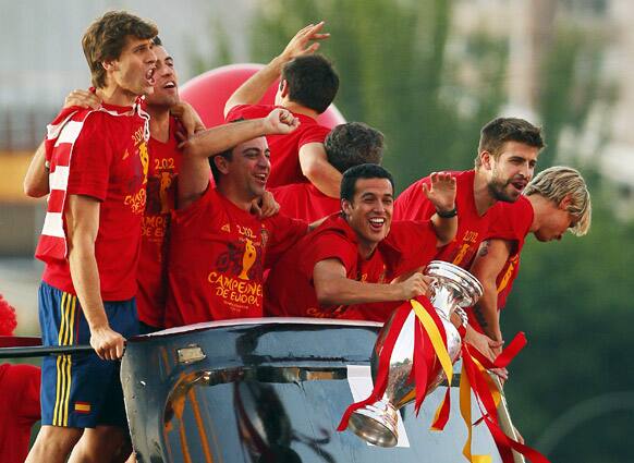 Spain's Pedro, third right, holds the trophy with teammates during the celebration of the Euro 2012 soccer championship in Madrid.