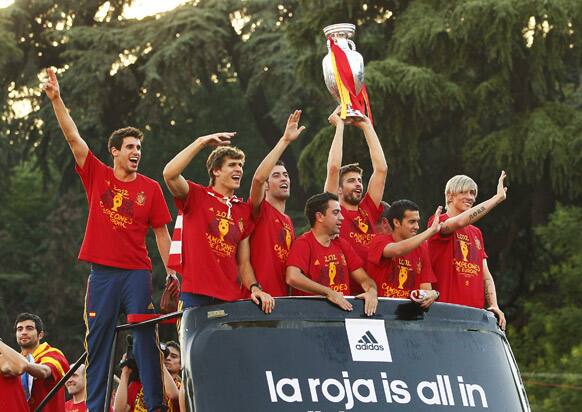 Gerard Pique holds the trophy with teammates during the celebration of the Euro 2012 soccer championship in Madrid.