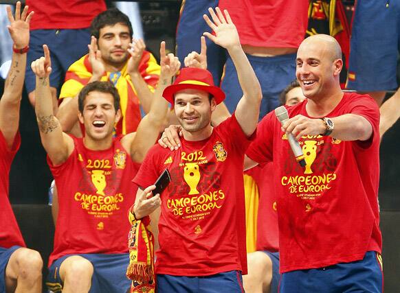 Andres Iniesta, centre, Pepe Reina, right, and Cesc Fabregas, left, greet the public during the celebration of the Euro 2012 soccer championship in Madrid.