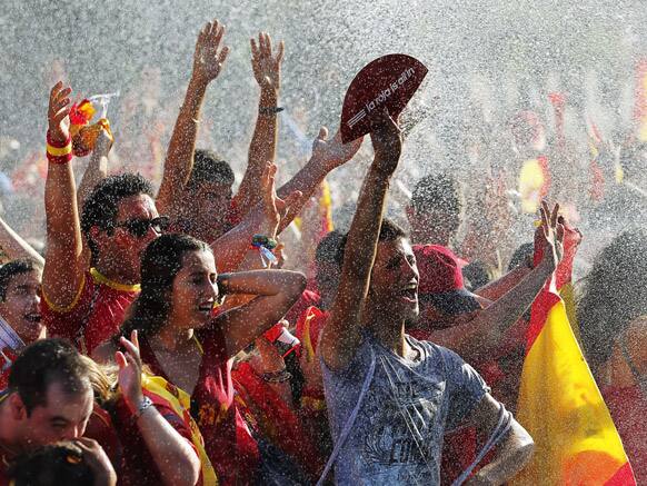 Spanish fans wave their hands showing a banner reading 