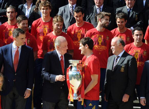 Spain's national soccer team captain Iker Casillas gives the Euro 2012 trophy to Spain's King Juan Carlos next to his coach Vicente del Bosque and Crown Prince Felipe at the Zarzuela Palace in Madrid.